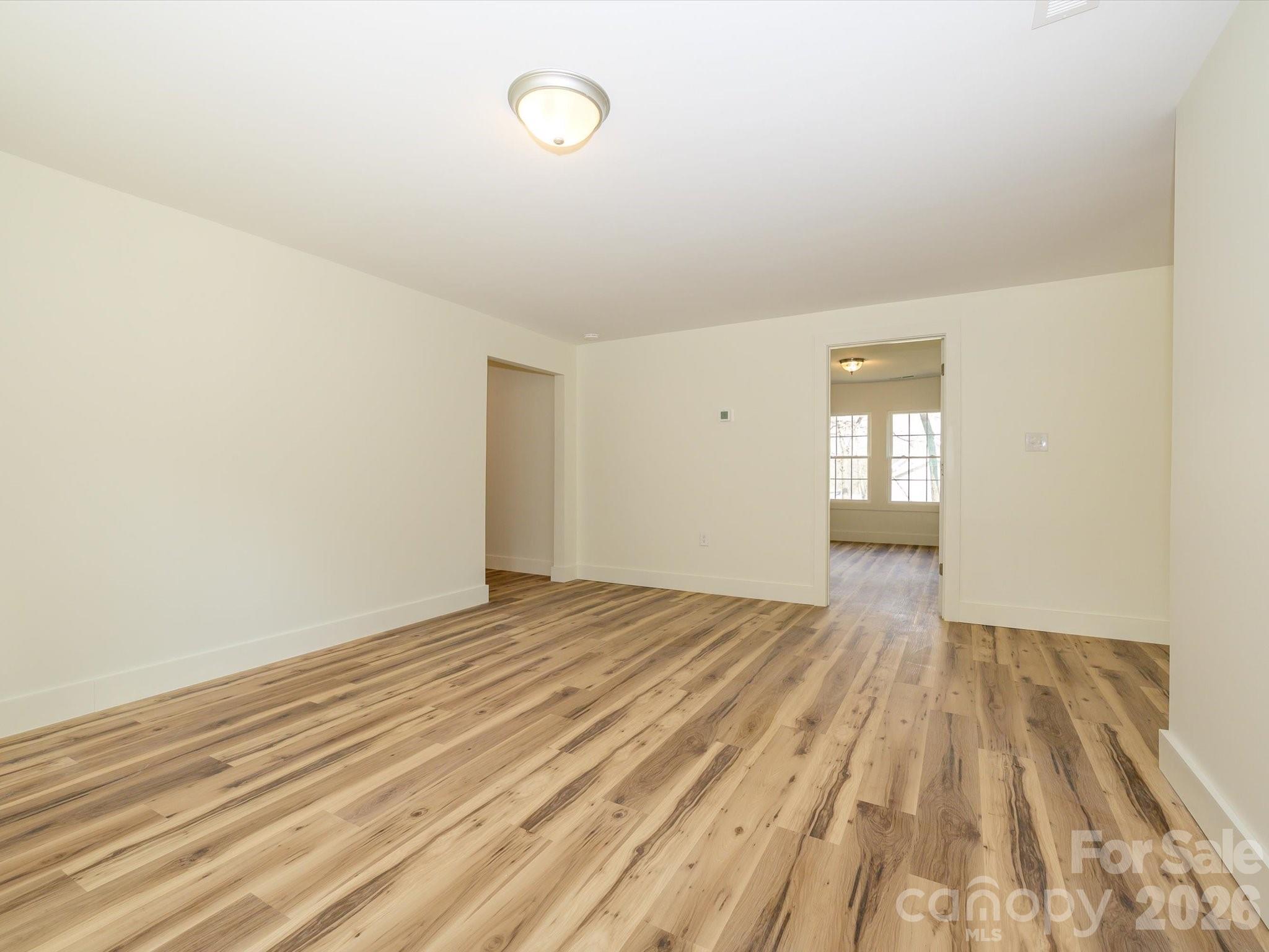 156 Hartsell School Road Southwest Concord, NC 28027 - Photo 9 of 28 a view of empty room with wooden floor and fan