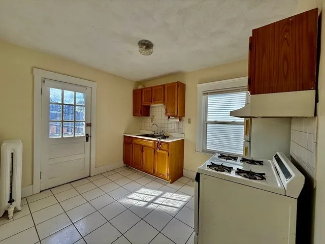 a kitchen with a stove a sink and a cabinets