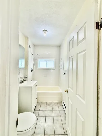 a bathroom with a sink a toilet a mirror and a bathtub