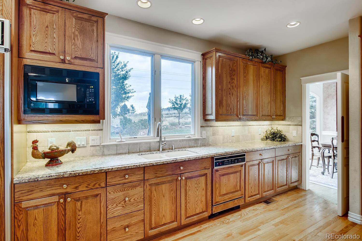 75 North Ranch Road Littleton, CO 80127 - Photo 12 of 33 a kitchen with stainless steel appliances granite countertop wooden cabinets a sink and a window
