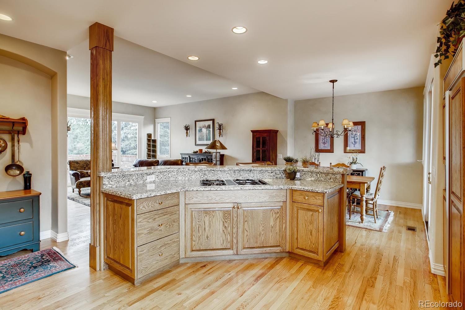 75 North Ranch Road Littleton, CO 80127 - Photo 14 of 33 a kitchen with kitchen island granite countertop a sink cabinets and wooden floor