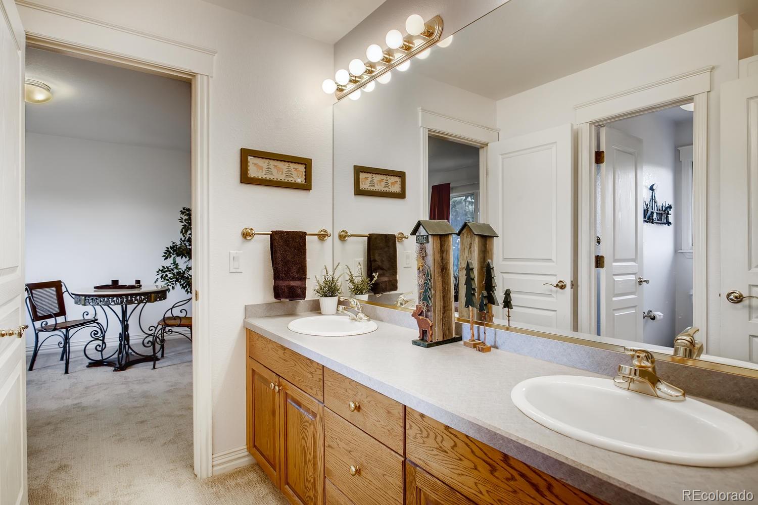 75 North Ranch Road Littleton, CO 80127 - Photo 28 of 33 a bathroom with double vanity sinks a vanity and a mirror