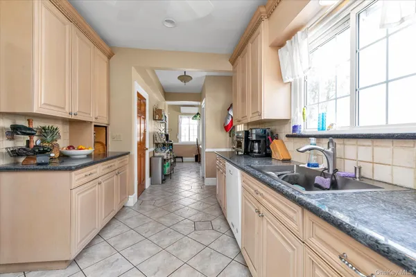 a kitchen with granite countertop a sink a counter top space and cabinets