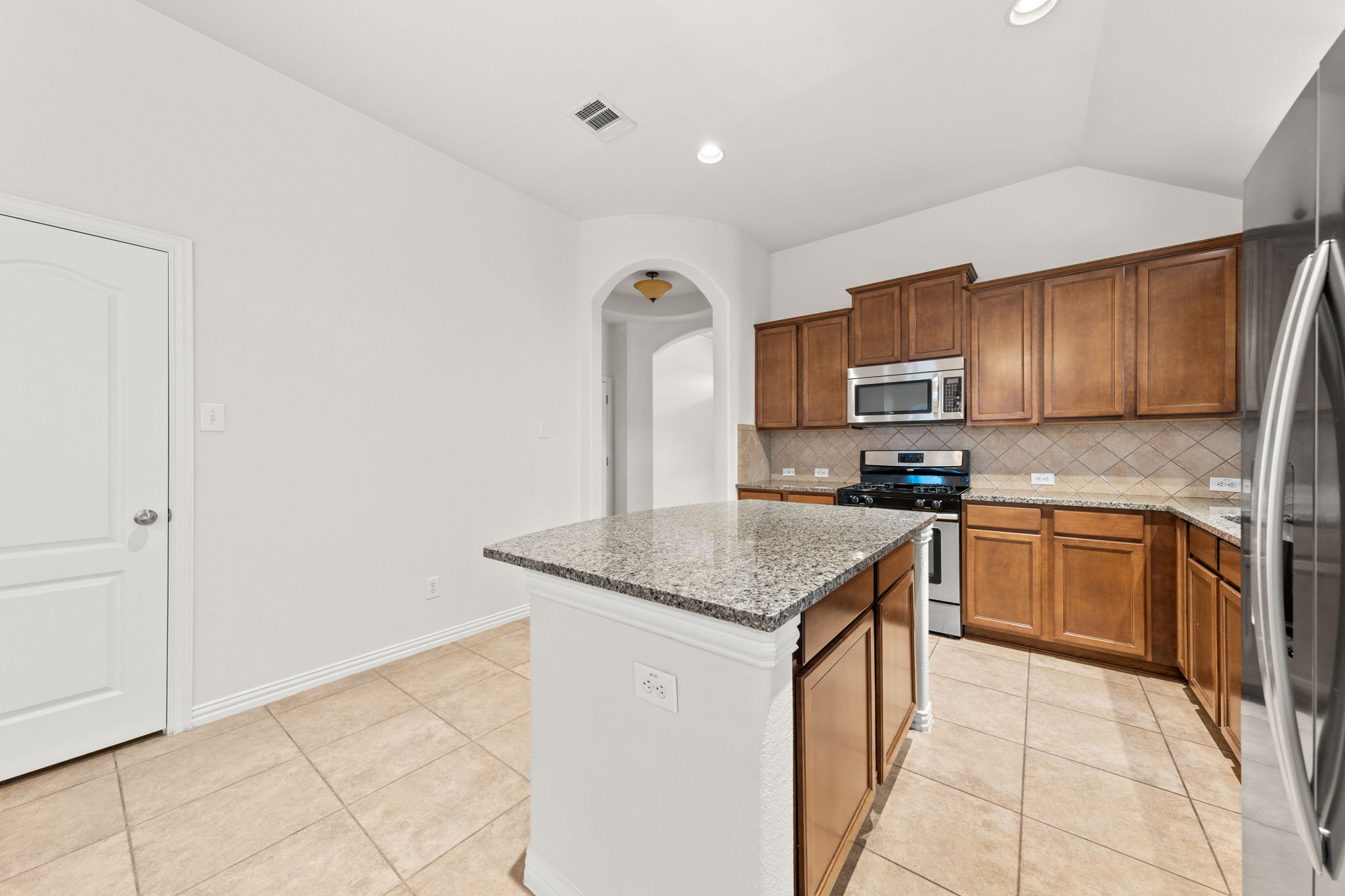 411 Tascate Street Georgetown, TX 78628 - Photo 14 of 41 Culinary aspirations come alive in this kitchen, featuring an inviting island and robust cabinetry.