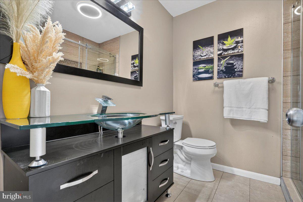 8930 Krewstown Road, Unit 310 Philadelphia, PA 19115 - Photo 13 of 32 a bathroom with a sink mirror vanity and toilet