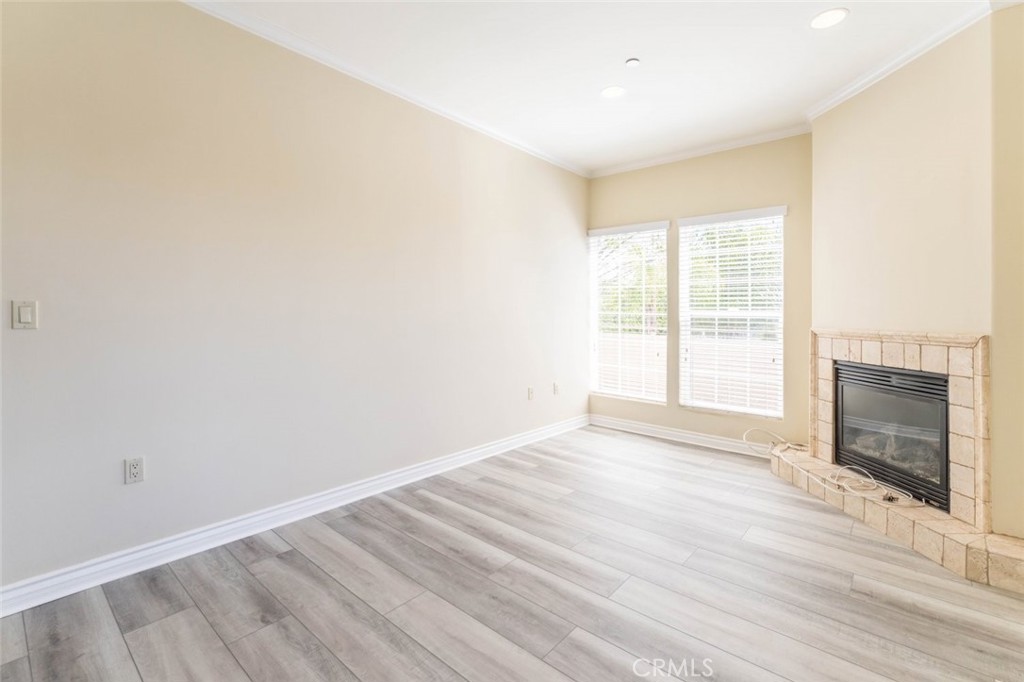 511 East Harvard Road, Unit 101 Burbank, CA 91501 - Photo 22 of 29 a view of an empty room with wooden floor fireplace and a window