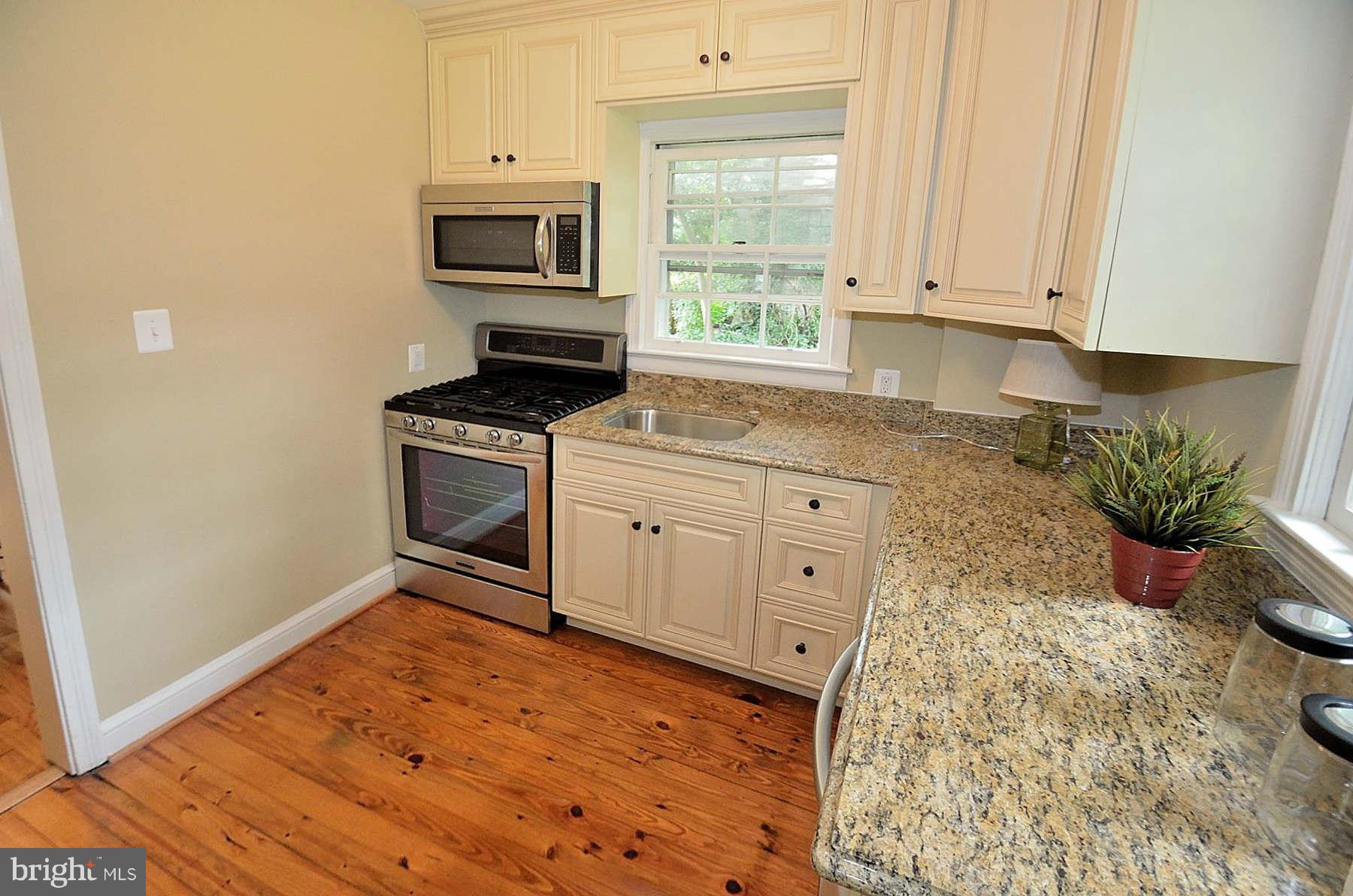 2423 Ridge Rd Drive Alexandria, VA 22302 - Photo 9 of 19 a kitchen with granite countertop a stove a sink and a microwave