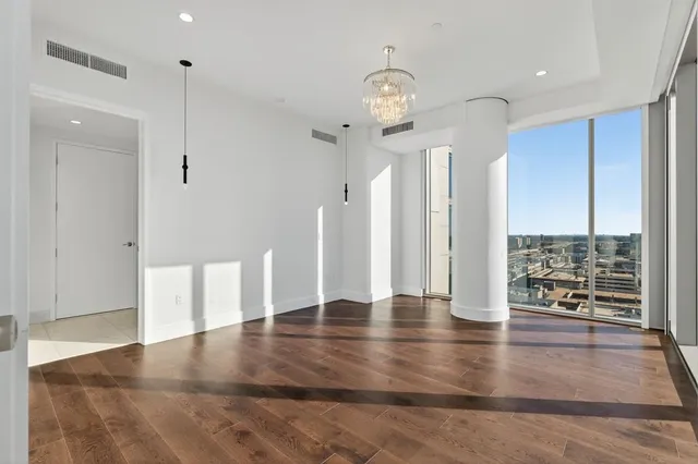 an empty room with wooden floor and outdoor view