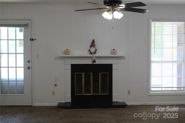 a view of an empty room with a chandelier fan