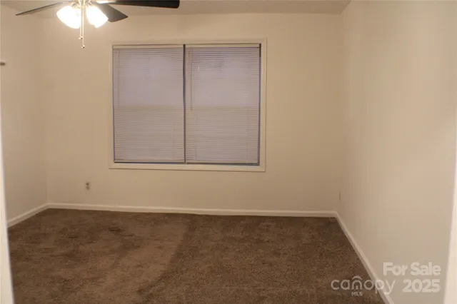 a view of an empty room with a ceiling fan