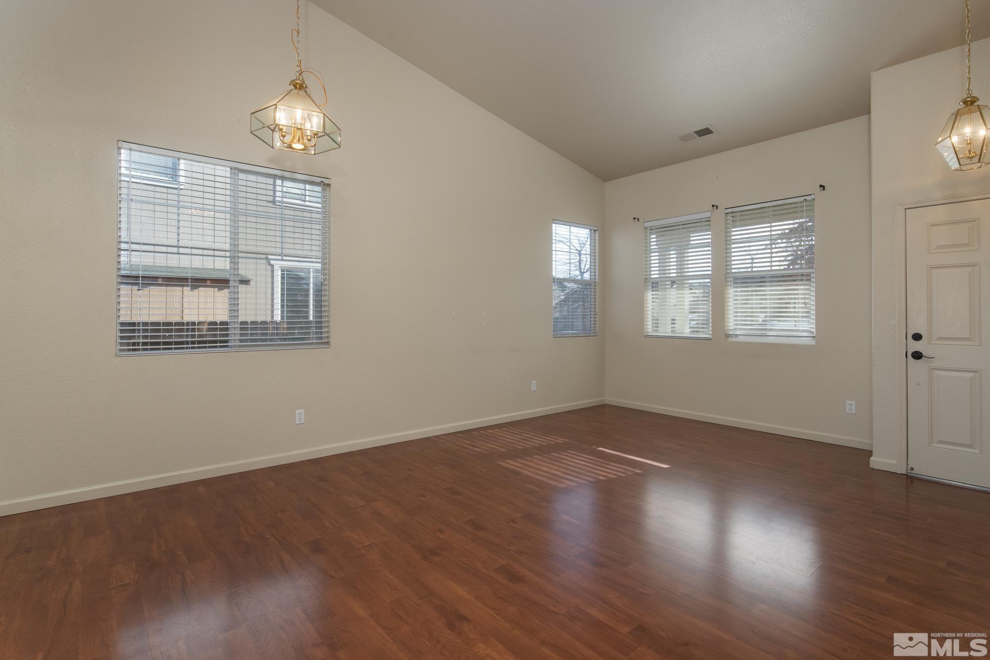 8987 Sorcha Street Reno, NV 89506 - Photo 11 of 29 an empty room with wooden floor and windows