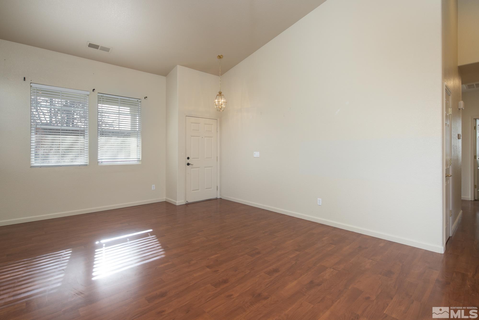 8987 Sorcha Street Reno, NV 89506 - Photo 13 of 29 an empty room with wooden floor and windows