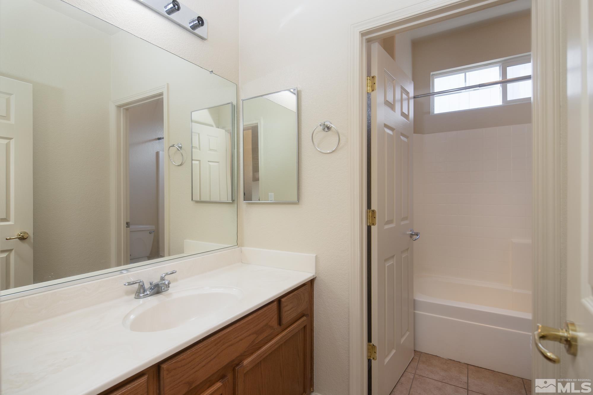 8987 Sorcha Street Reno, NV 89506 - Photo 19 of 29 a bathroom with a bathtub sink vanity and mirror