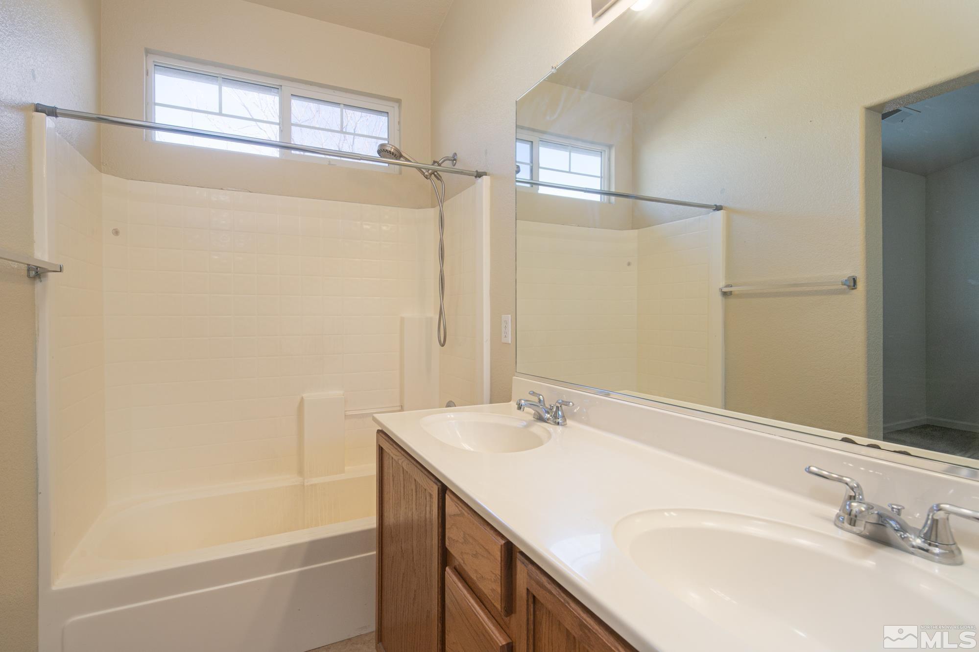8987 Sorcha Street Reno, NV 89506 - Photo 23 of 29 a bathroom with a tub sink and mirror
