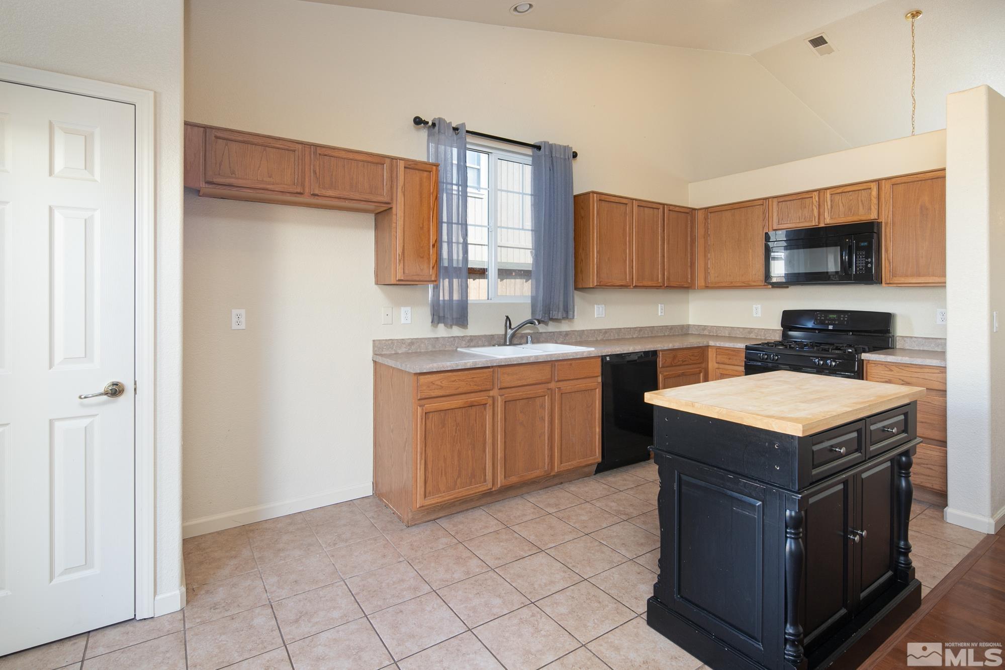 8987 Sorcha Street Reno, NV 89506 - Photo 5 of 29 a kitchen with a stove top oven a sink a counter top space and cabinets