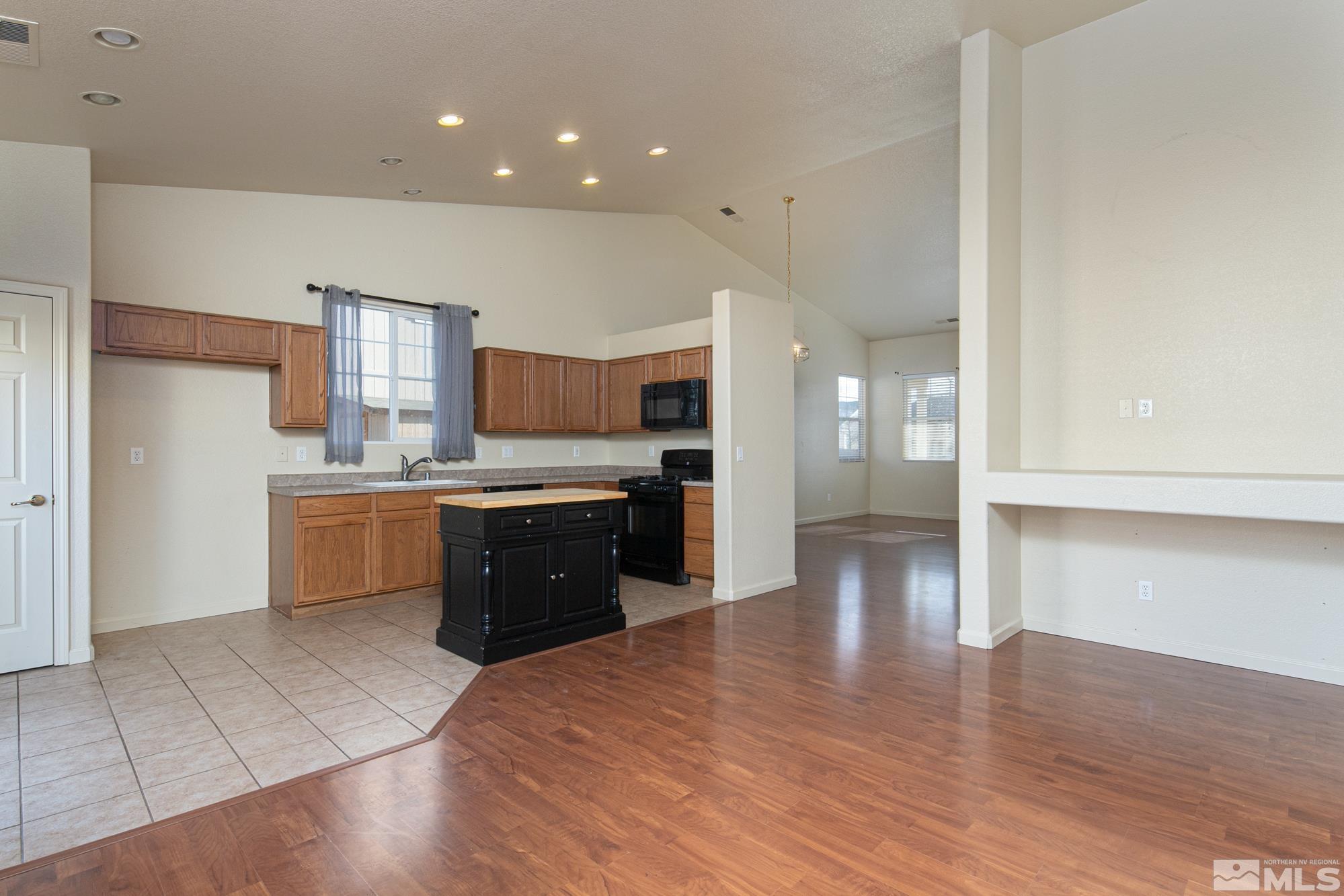 8987 Sorcha Street Reno, NV 89506 - Photo 6 of 29 a large kitchen with wooden floors and stainless steel appliances