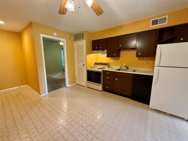 a view of a kitchen with a sink and a refrigerator
