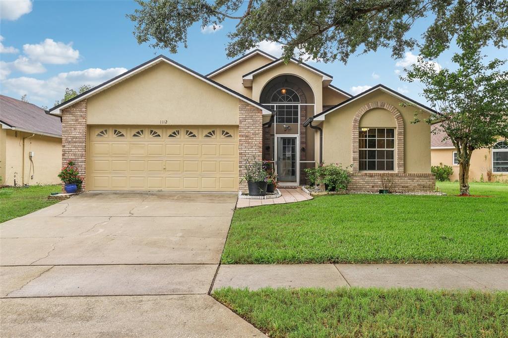 1112 Twin Rivers Boulevard Oviedo, FL 32766 - Photo 1 of 1 a front view of a house with a yard and garage