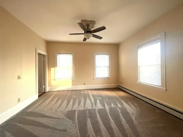 a view of a livingroom with a window and a ceiling fan
