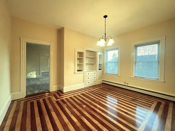 a view of a room with wooden floor and windows