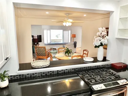 a kitchen with granite countertop a stove sink and cabinets