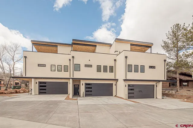 a front view of a house with yard and parking