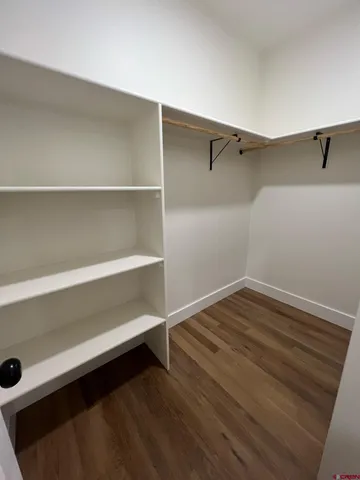 a view of walk in closet with empty racks