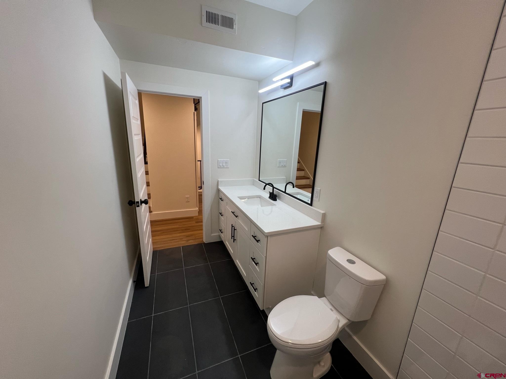2398 Ridge Cir Drive, Unit B Grand Junction, CO 81507 - Photo 16 of 30 a bathroom with a toilet sink and mirror