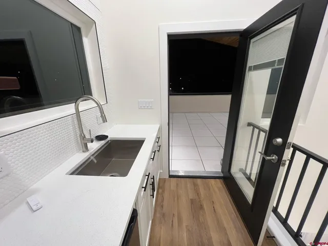 a kitchen with stainless steel appliances white cabinets and wooden floor