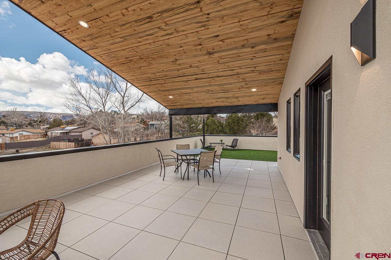 2398 Ridge Cir Drive, Unit B Grand Junction, CO 81507 - Photo 20 of 30 a view of a patio with table and chairs with wooden floor and fence