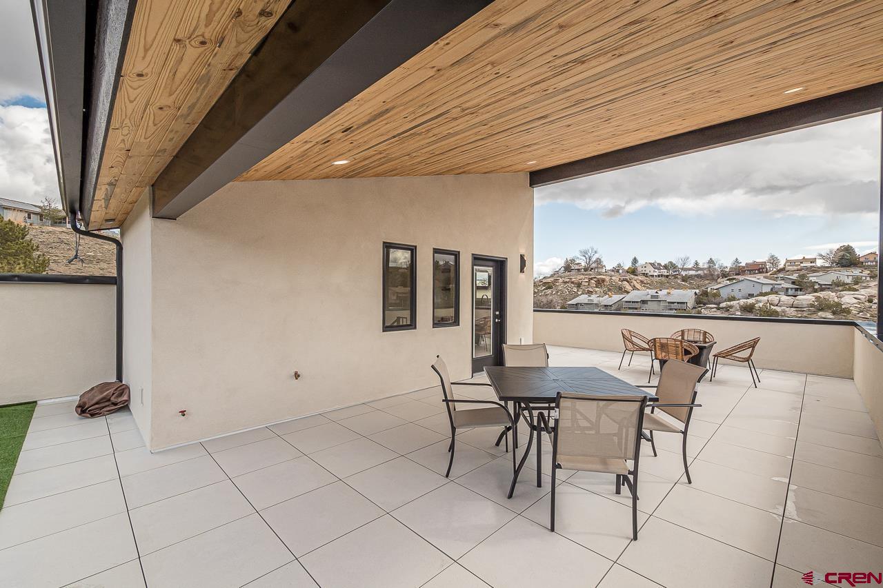 2398 Ridge Cir Drive, Unit B Grand Junction, CO 81507 - Photo 22 of 30 a dining room with furniture and a floor to ceiling window