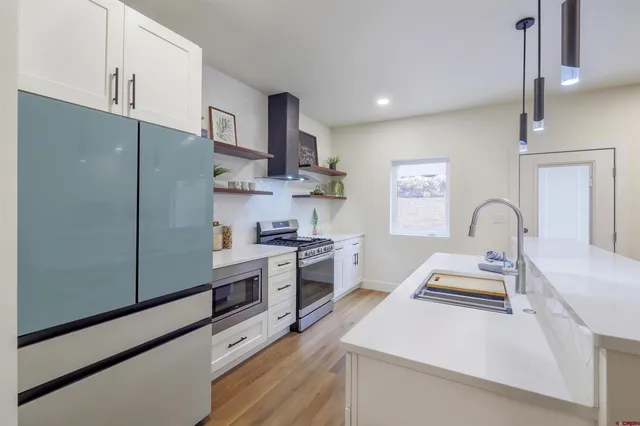 a kitchen with stainless steel appliances a stove refrigerator sink and cabinets