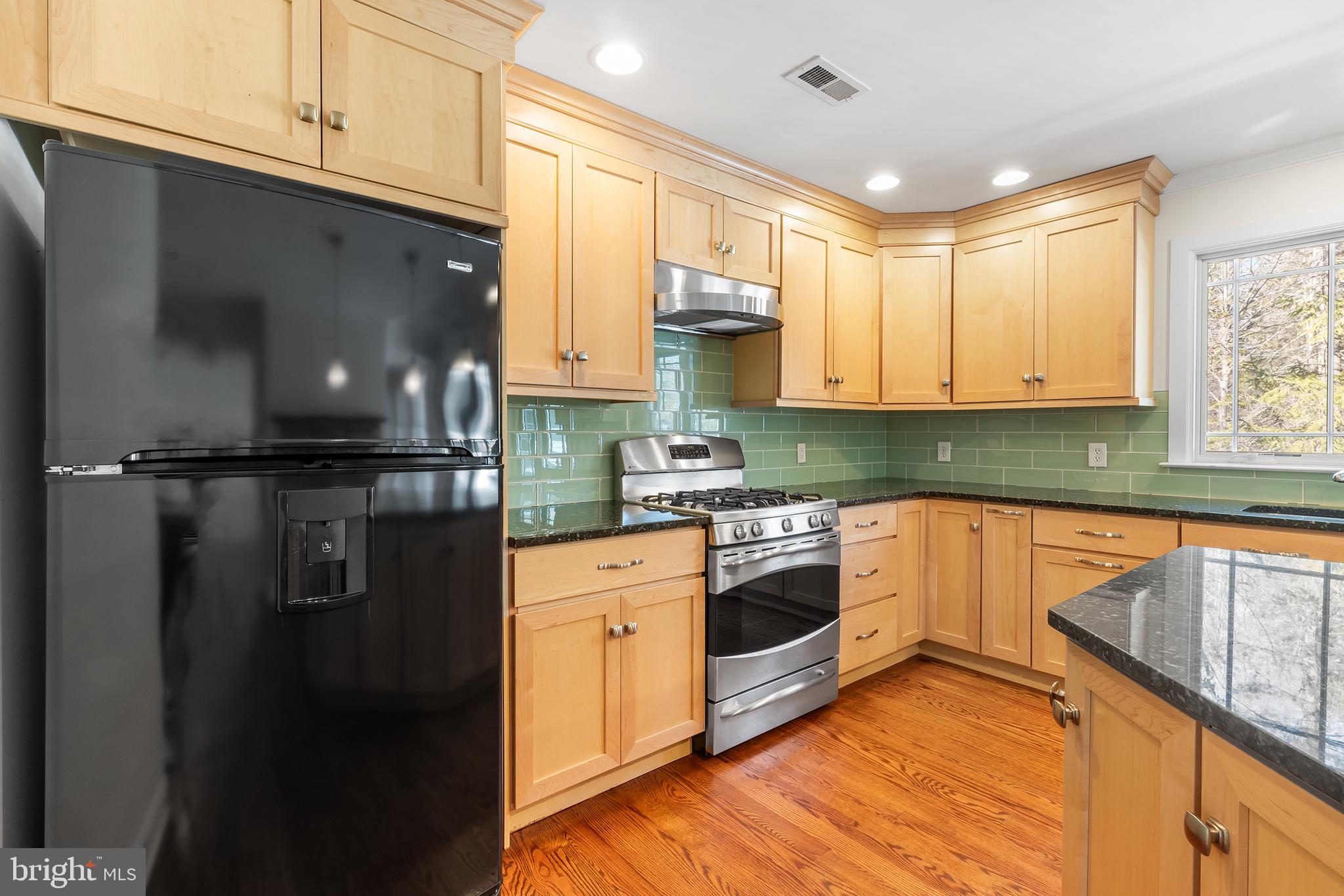 117 Glen Valley Road Yardley, PA 19067 - Photo 11 of 34 a kitchen with stainless steel appliances granite countertop a refrigerator a sink dishwasher a stove and white countertops with wooden floor