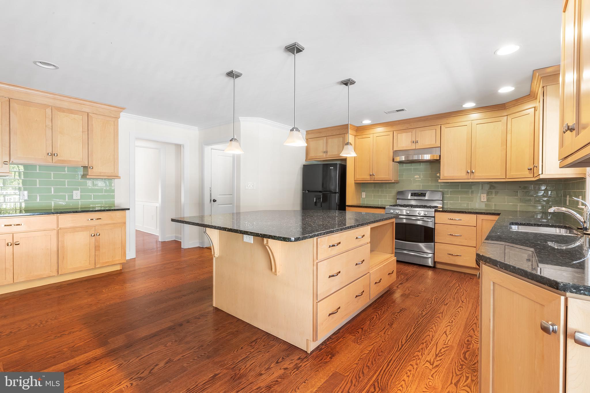 117 Glen Valley Road Yardley, PA 19067 - Photo 9 of 34 a kitchen with stainless steel appliances granite countertop a stove a sink a refrigerator and white cabinets with wooden floor