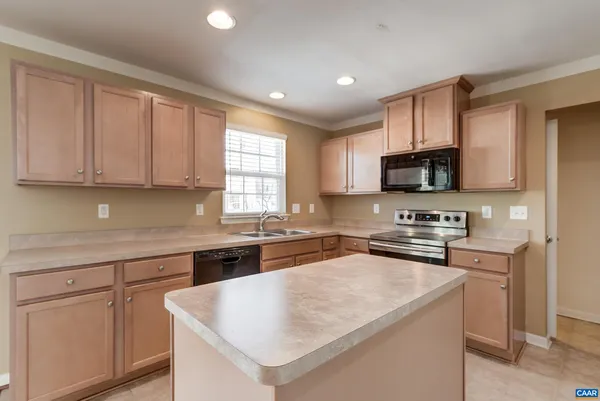 a kitchen with cabinets appliances a sink and a counter top space