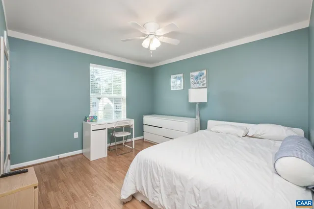 a bedroom with a bed and a table in it with window