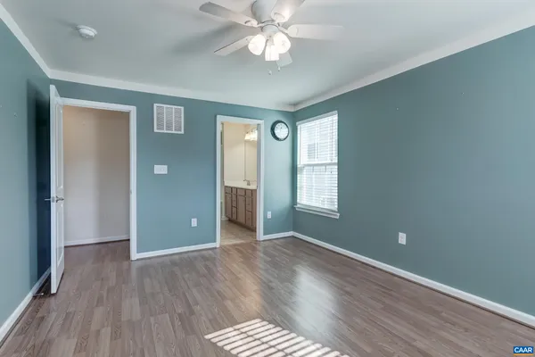 a view of an empty room with window and wooden floor