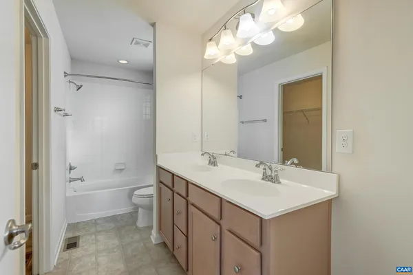 a bathroom with a sink a toilet and a large mirror