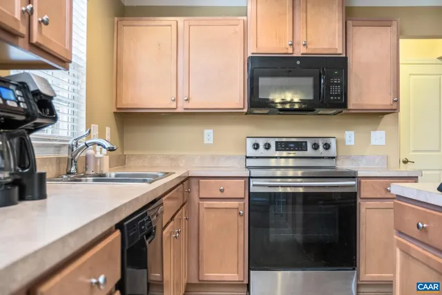a kitchen with stainless steel appliances granite countertop a sink and a stove