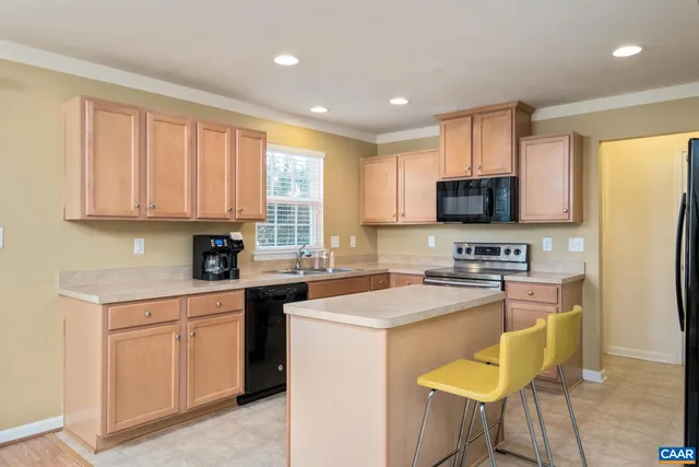 a kitchen with a stove a sink a microwave a refrigerator and cabinets