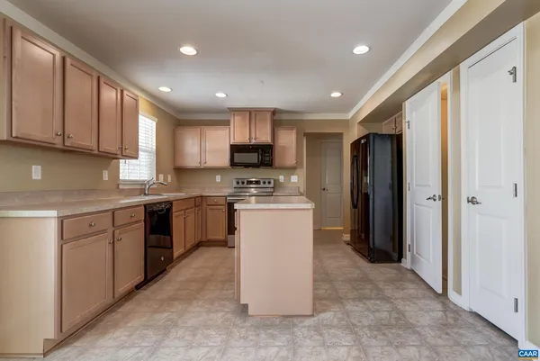 a kitchen with a refrigerator a sink and a stove top oven