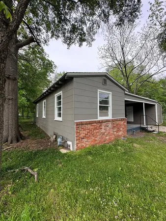 a front view of house with a garden