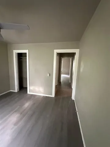 an empty room with wooden floor and closet