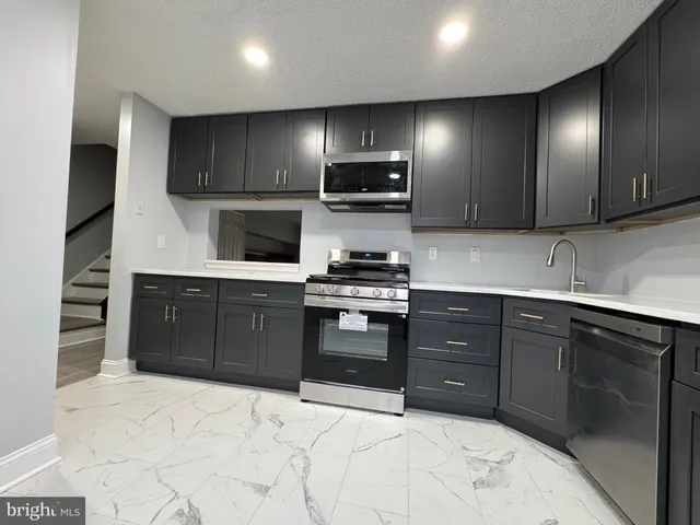 a kitchen with stainless steel appliances granite countertop a stove and a sink