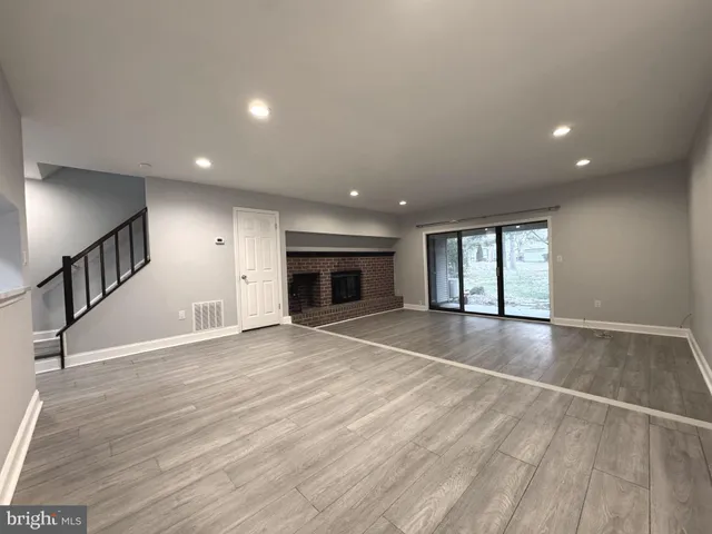 an empty room with wooden floor and fireplace
