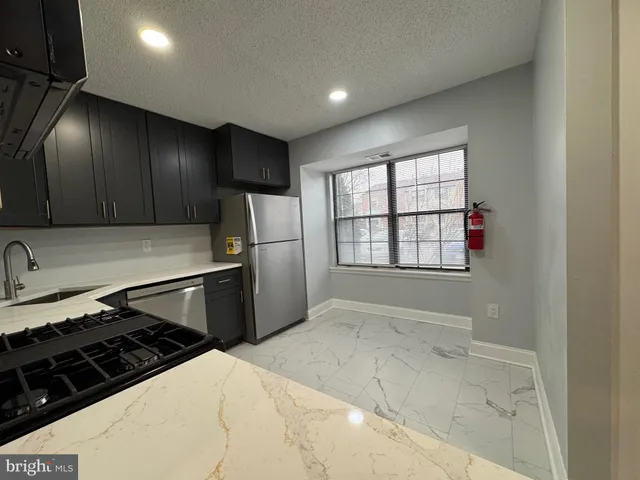 a kitchen with a refrigerator and a stove top oven
