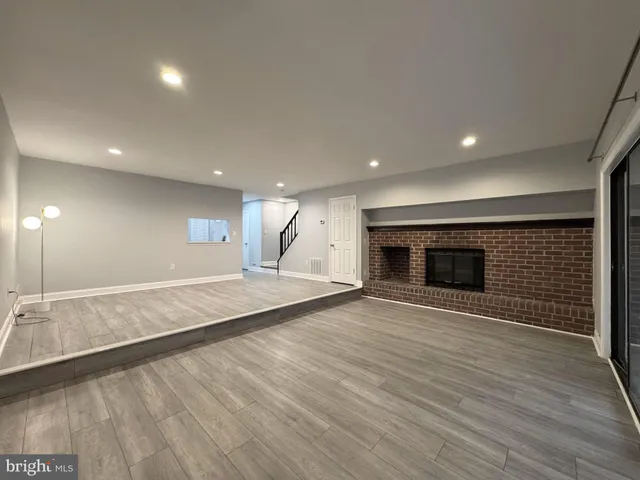 an empty room with wooden floor and fireplace