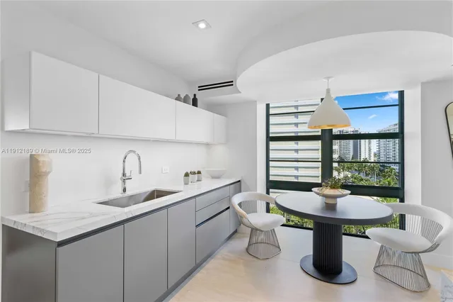 a large white bed sitting in a bedroom next to a large window