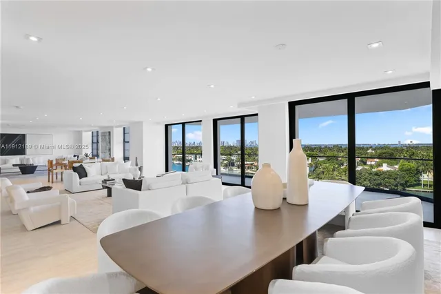 a living room with furniture a rug potted plant and a window