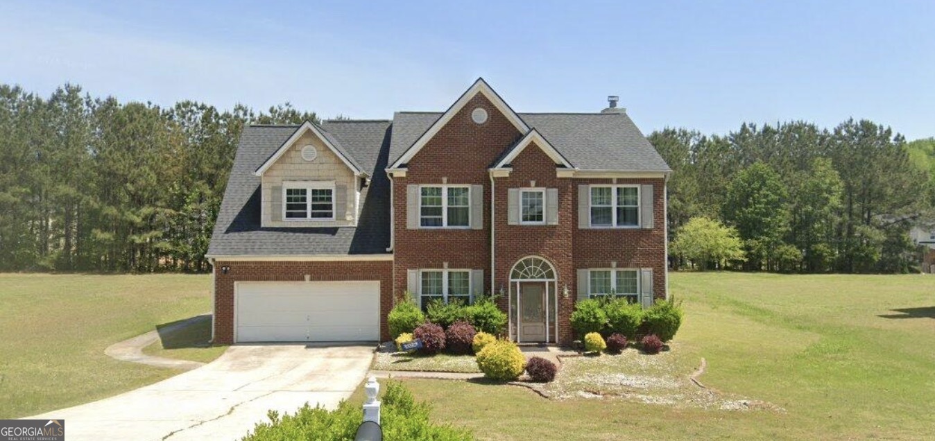 a front view of a house with a yard and a garage